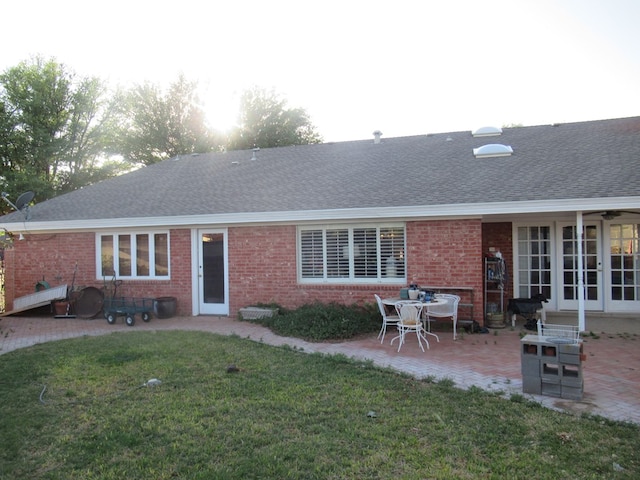 back of property with a patio area and a lawn