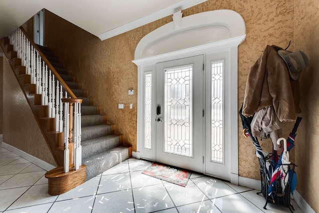 tiled foyer featuring plenty of natural light and crown molding