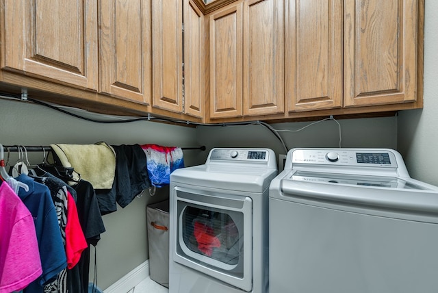 laundry room with washing machine and dryer and cabinets