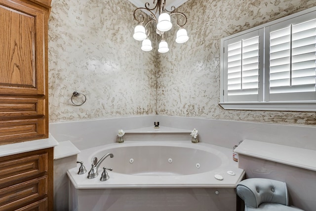 bathroom featuring a chandelier and a tub