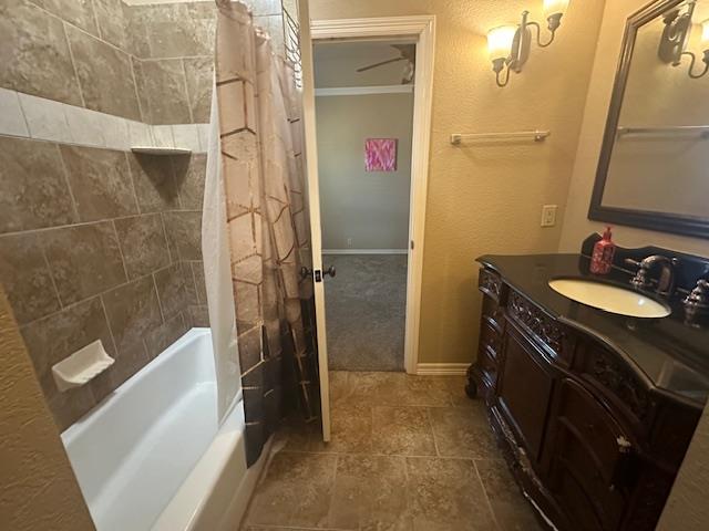 full bath with baseboards, shower / tub combo with curtain, and vanity