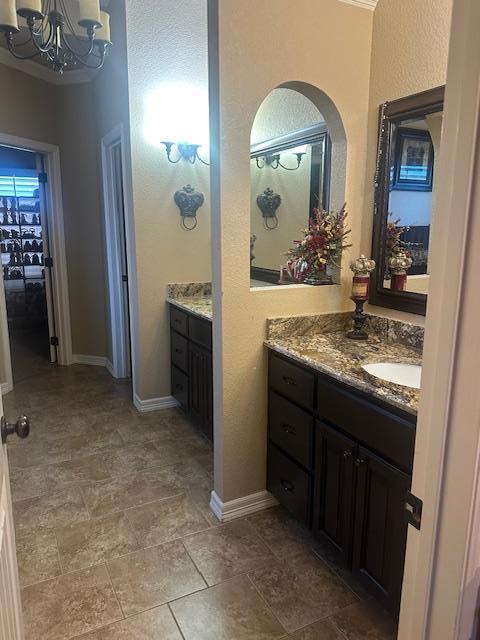 bathroom featuring vanity, baseboards, and a chandelier