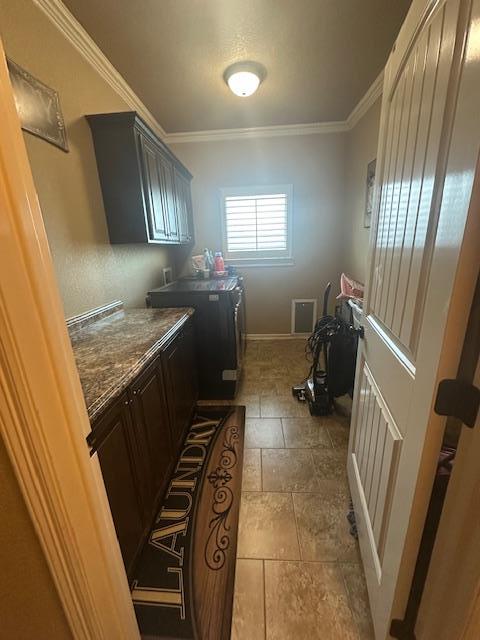 laundry room with baseboards, cabinet space, washer hookup, and crown molding