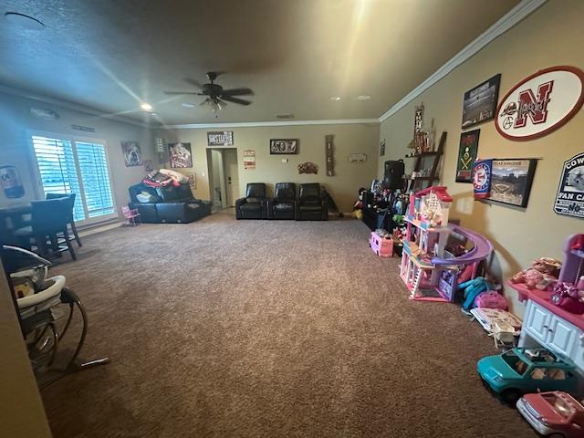 playroom featuring crown molding, carpet, and ceiling fan