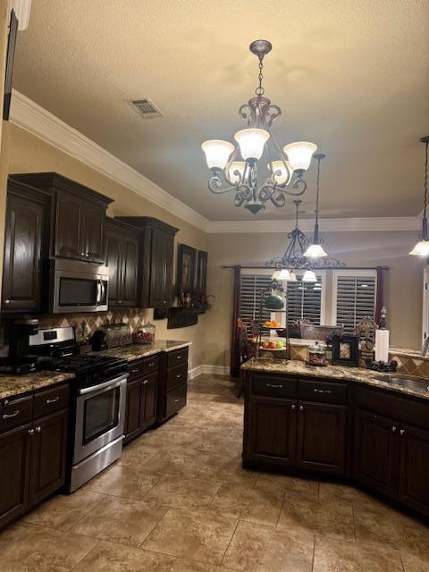 kitchen featuring visible vents, a sink, appliances with stainless steel finishes, crown molding, and decorative backsplash