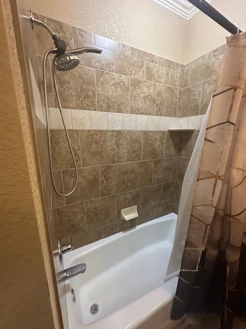 bathroom featuring shower / tub combo with curtain and a textured wall