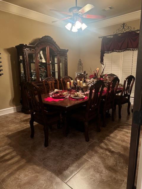 dining room with ornamental molding, baseboards, visible vents, and ceiling fan