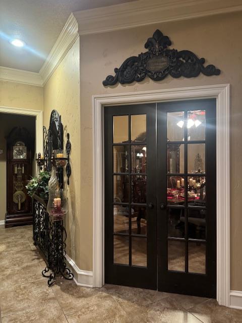 entryway with crown molding and french doors