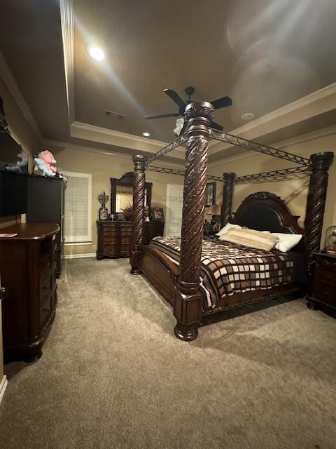 carpeted bedroom featuring a raised ceiling, ceiling fan, and ornamental molding