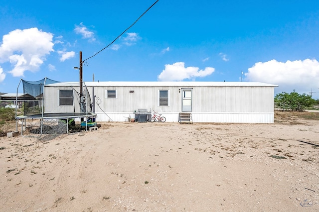 back of property featuring a trampoline