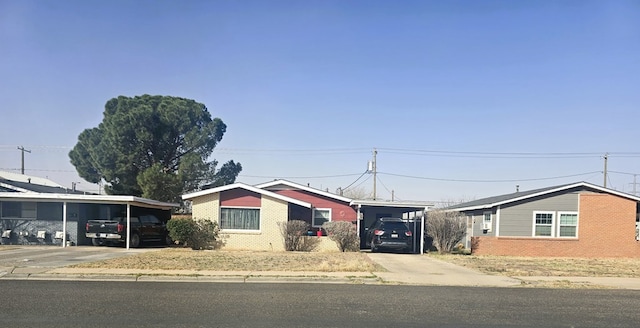 view of front facade featuring a carport, brick siding, and driveway