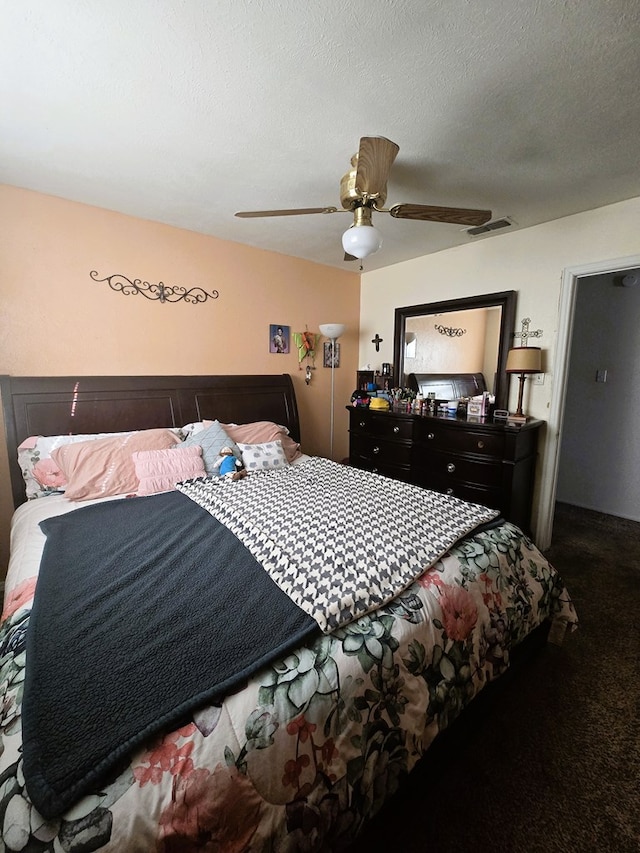 bedroom with visible vents, a textured ceiling, and a ceiling fan