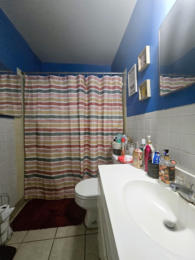 bathroom featuring vanity, tile patterned flooring, curtained shower, tile walls, and toilet