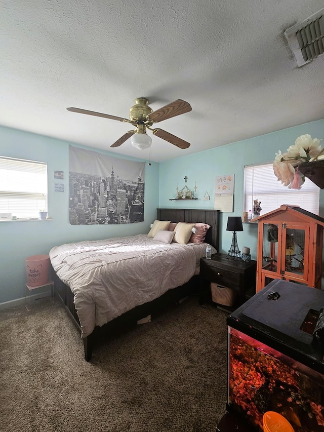 bedroom with visible vents, carpet flooring, a textured ceiling, and a ceiling fan