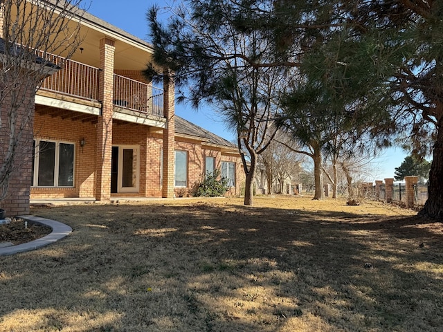 view of yard with fence and a balcony