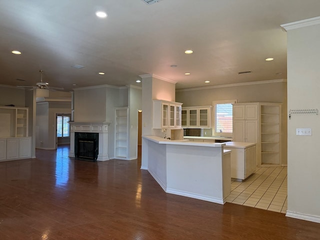 kitchen with a healthy amount of sunlight, light wood-style floors, and glass insert cabinets