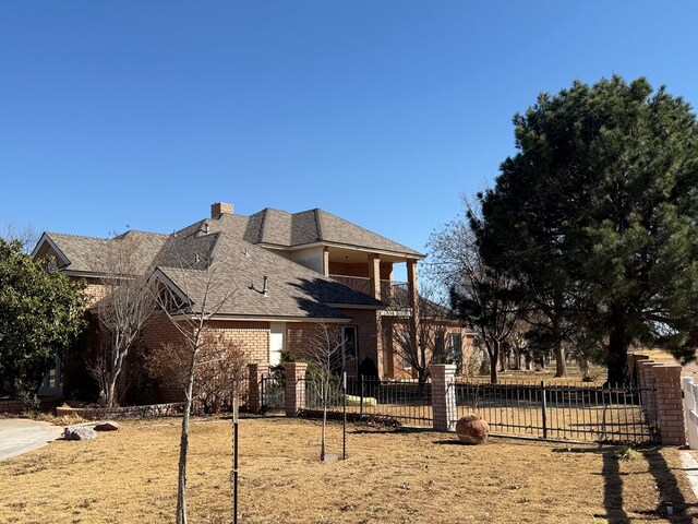 view of front of house featuring a chimney, fence, and brick siding