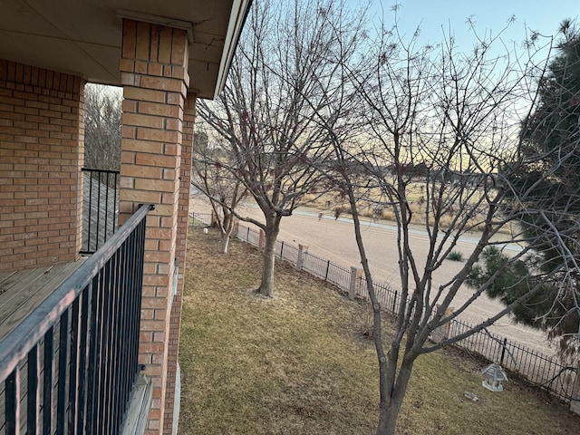 view of yard featuring a balcony and fence