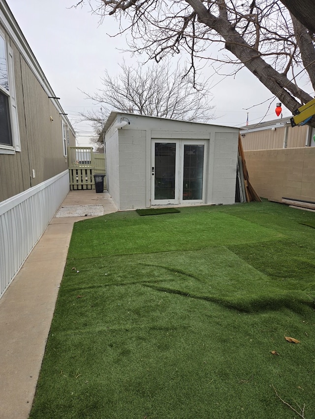 back of house with an outdoor structure and a lawn