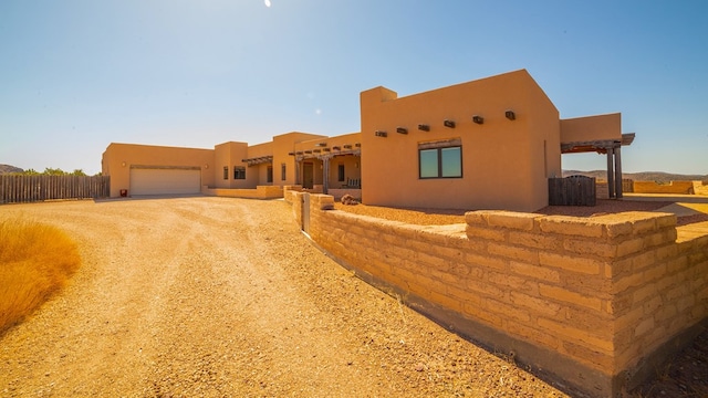 pueblo revival-style home featuring a garage