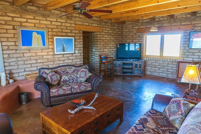 living room with beamed ceiling, ceiling fan, and brick wall