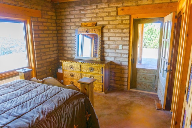 bedroom featuring carpet floors, multiple windows, and brick wall