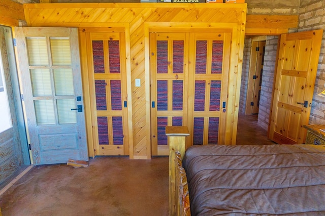 unfurnished bedroom featuring carpet flooring, wood walls, and brick wall