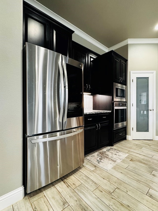 kitchen with wood tiled floor, appliances with stainless steel finishes, dark cabinets, and crown molding