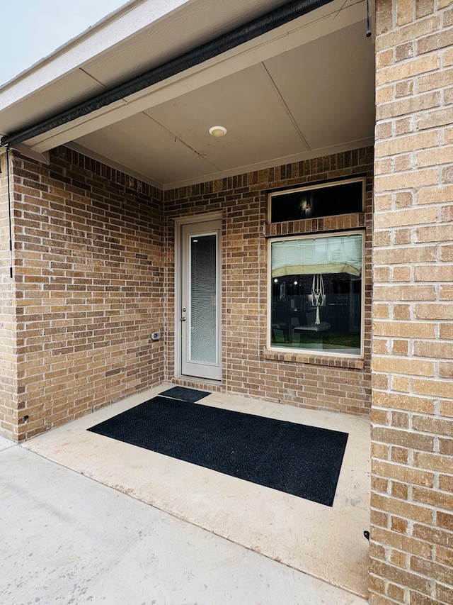 doorway to property with brick siding