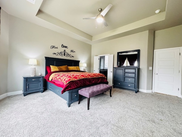 bedroom with carpet flooring, a raised ceiling, and baseboards