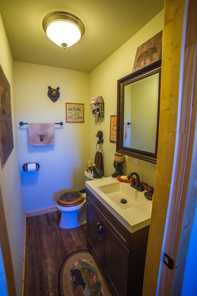 bathroom featuring toilet, vanity, and hardwood / wood-style flooring