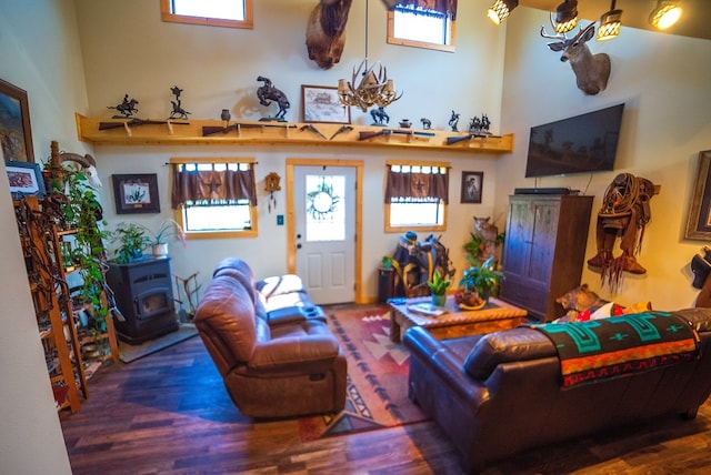 living room with a wood stove, dark hardwood / wood-style floors, and an inviting chandelier