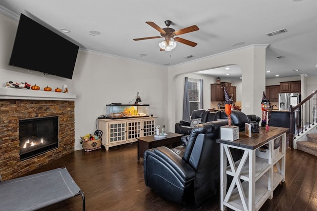 living room featuring a fireplace, dark hardwood / wood-style floors, ceiling fan, and ornamental molding