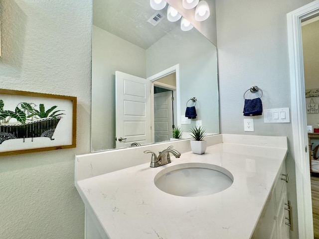 bathroom featuring a textured ceiling and vanity