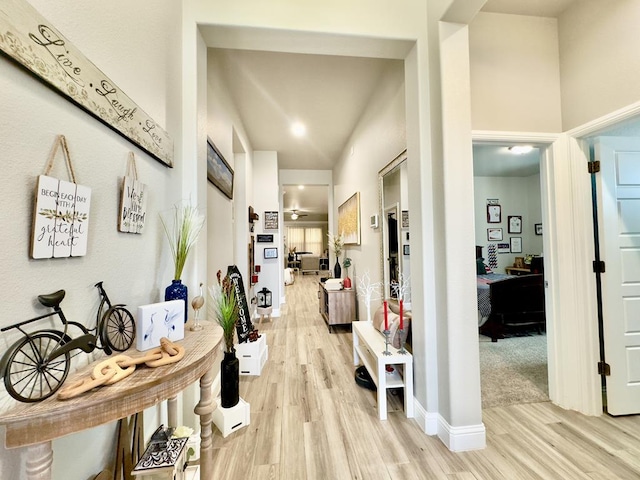 hall with light hardwood / wood-style flooring and a high ceiling