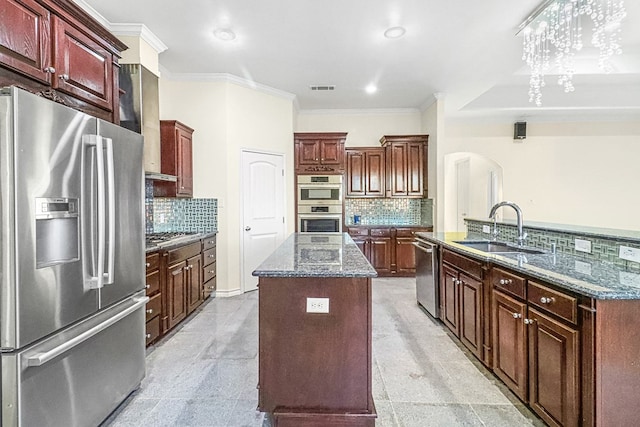 kitchen with a center island with sink, appliances with stainless steel finishes, decorative backsplash, crown molding, and sink