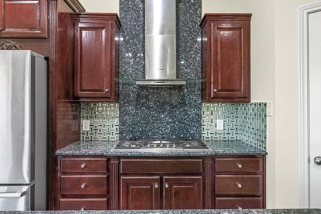 kitchen with decorative backsplash, appliances with stainless steel finishes, and wall chimney range hood