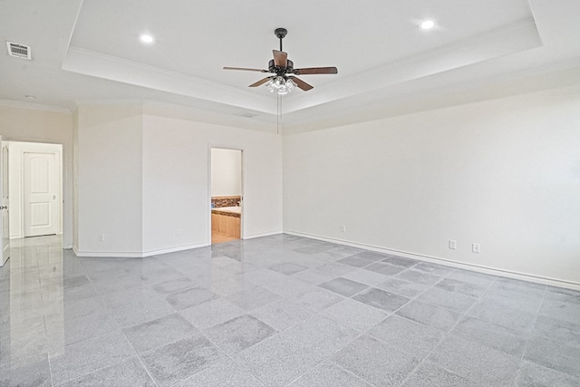 empty room featuring ceiling fan, a tray ceiling, and ornamental molding