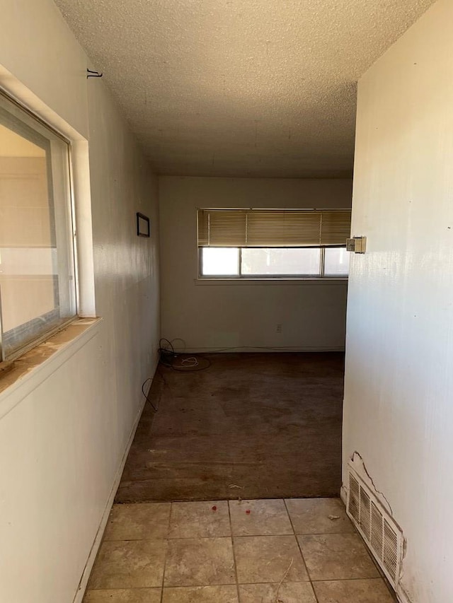 hallway with a textured ceiling