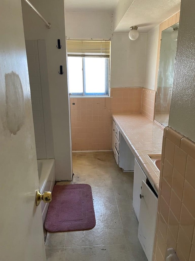 bathroom with tile walls and vanity