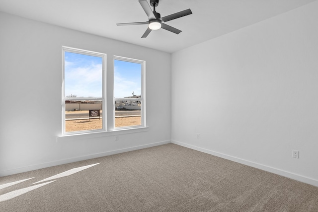 carpeted spare room featuring ceiling fan