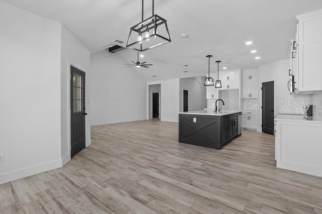 kitchen with white cabinetry, an island with sink, hanging light fixtures, and ceiling fan