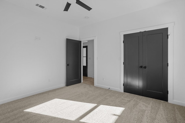 unfurnished bedroom with light carpet, a closet, and ceiling fan