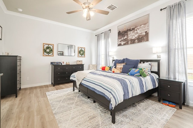 bedroom with light wood-type flooring, visible vents, ornamental molding, baseboards, and ceiling fan