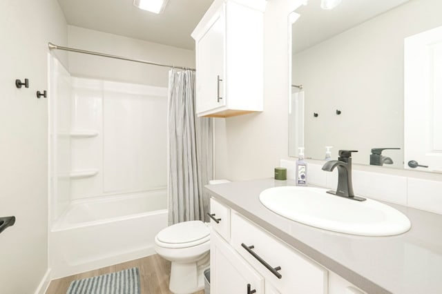 full bath with vanity, shower / tub combo, toilet, and wood finished floors