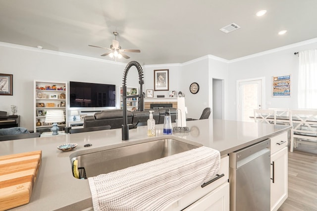 kitchen with a sink, dishwasher, open floor plan, and crown molding