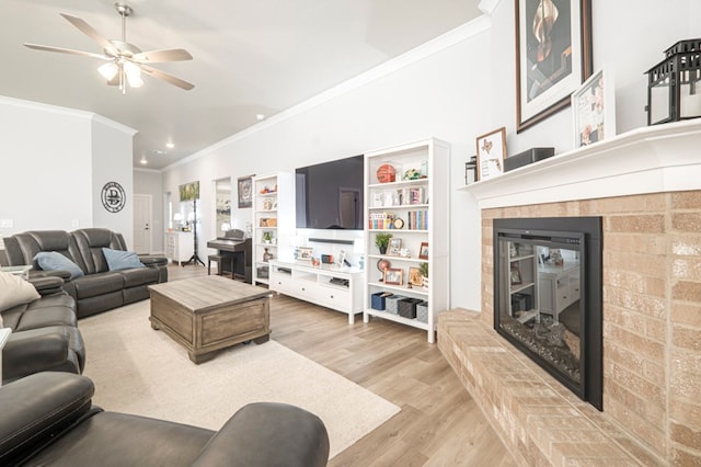 living area featuring light wood-type flooring, ornamental molding, recessed lighting, a tile fireplace, and a ceiling fan