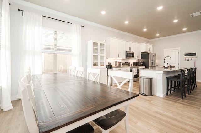 dining room with visible vents, recessed lighting, crown molding, and light wood-type flooring