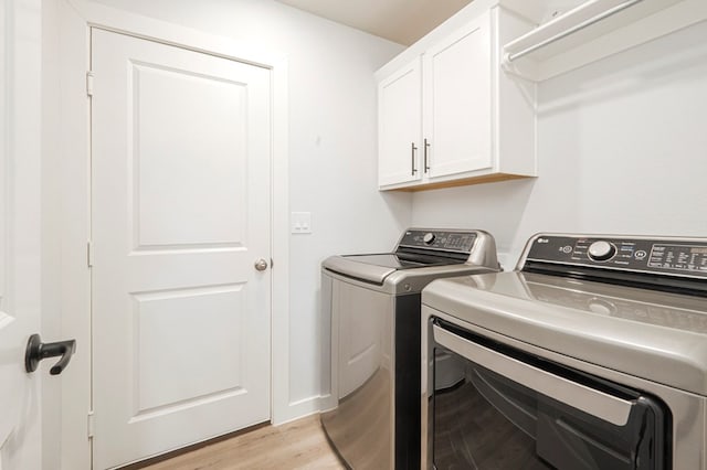 laundry area featuring cabinet space, washing machine and dryer, and light wood finished floors