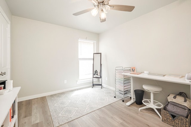 office area featuring baseboards, light wood-type flooring, and ceiling fan